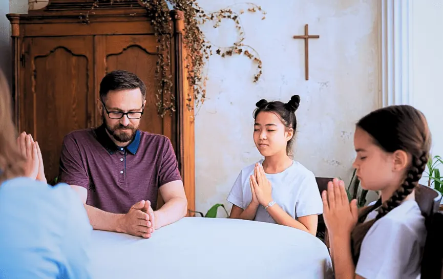 Oración del Padre Pío por la Familia Familia rezando junta con manos entrelazadas, reflejando devoción y unidad espiritual.