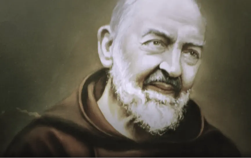 Padre Pio Oración Poderosa para Pedir Salud y Sanación Física, muestra una mano sosteniendo un rosario con una cruz metálica, iluminada por la luz cálida de una vela encendida al fondo.