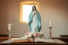 Reflexión Sobre La Intercesión de la Virgen Milagrosa: Una imagen de la Virgen con manto azul sobre un altar con velas y flores, iluminada por una suave luz, simbolizando esperanza y protección.